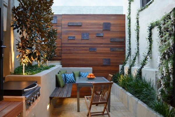small backyard wooden privacy wall dining area grill area