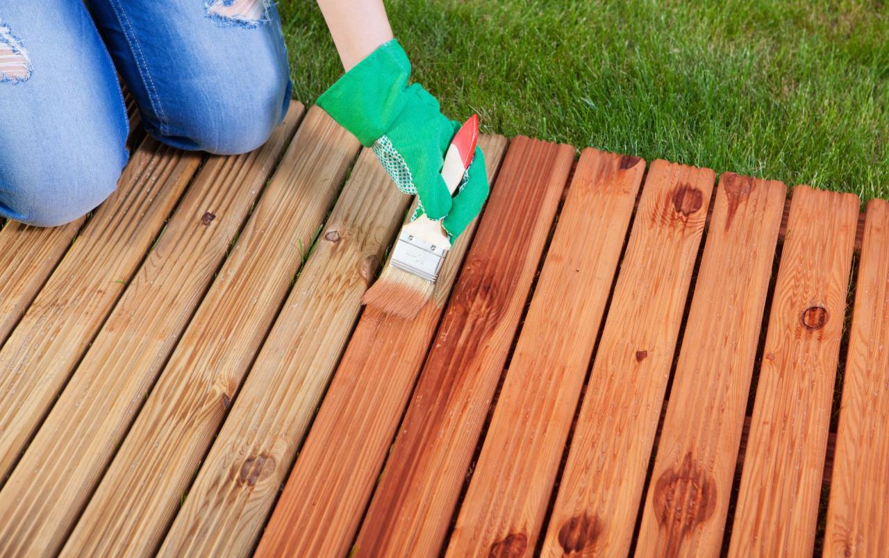 Applying protective varnish on a patio wooden floor
