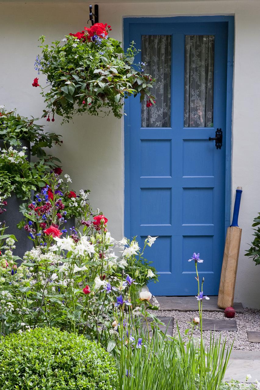 Blue front door with cricket bat and planters