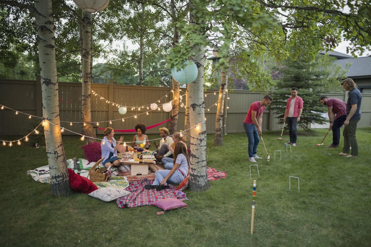 Friends playing croquet and eating at backyard garden party